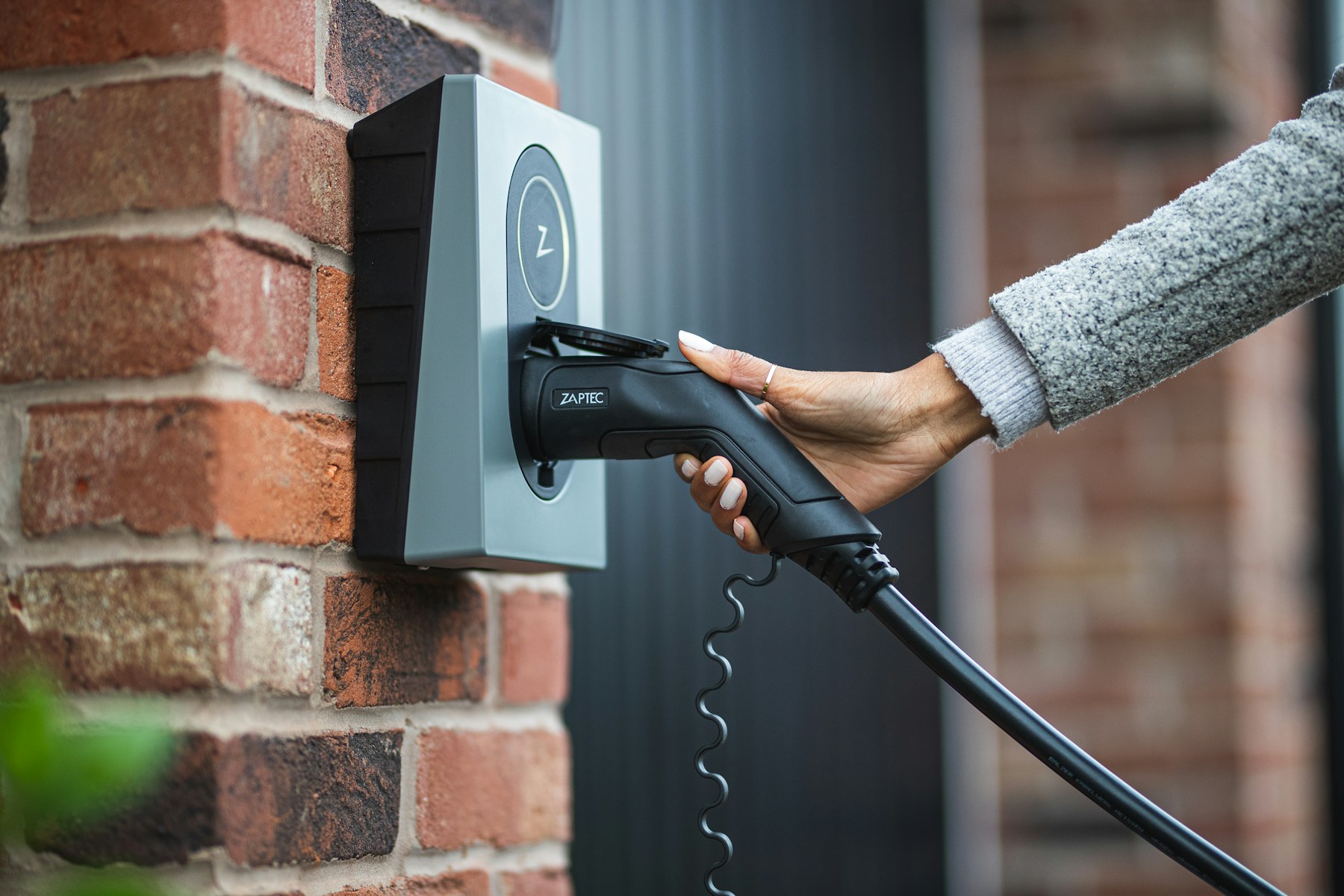 Close view of an EV charging connector and wall charger